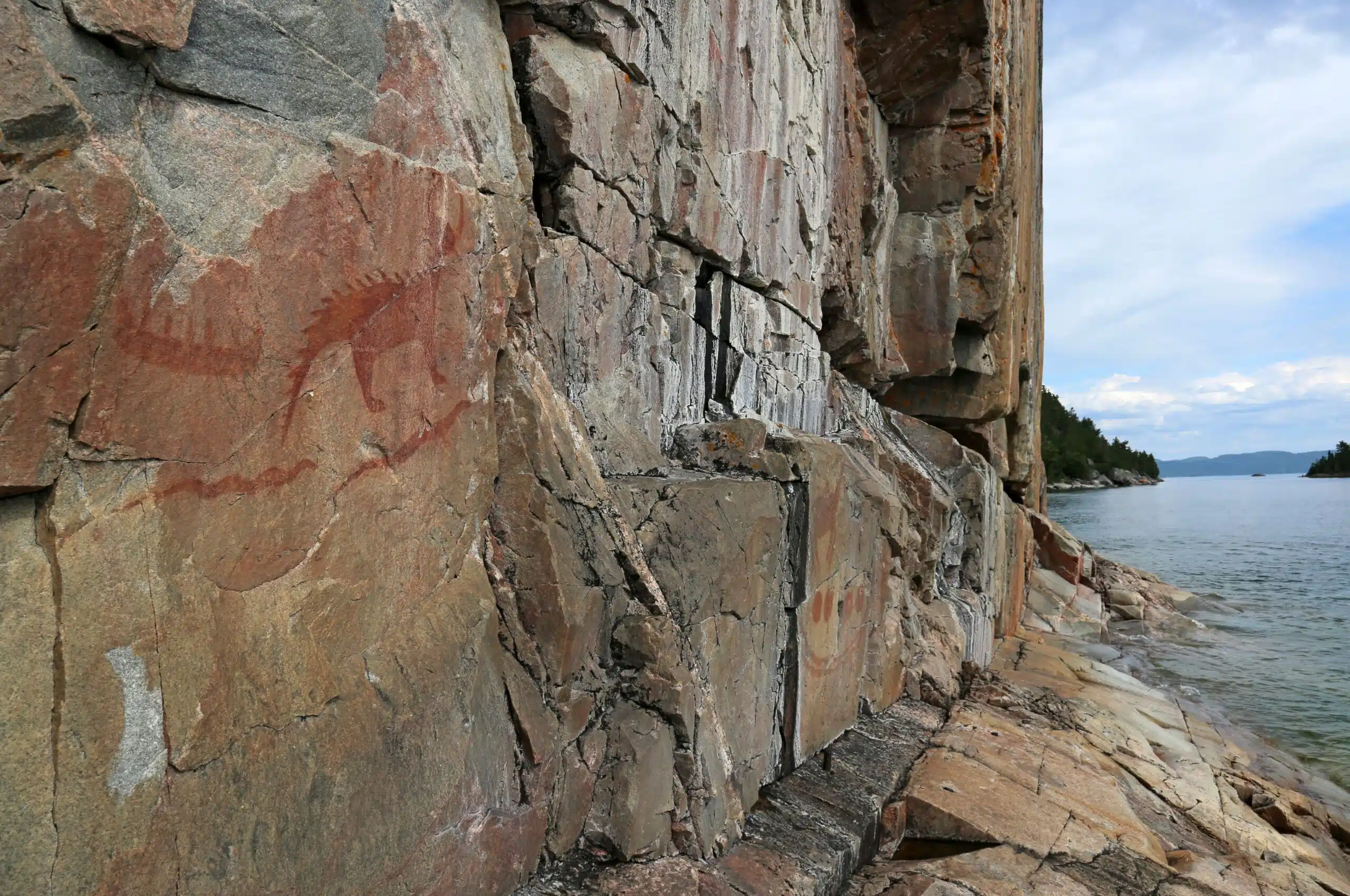 The Mishibizhiw or Great Lynx, along with canoes and serpents, are part of the Agawa Rock Pictographs. The site is found in Lake Superior Provincial Park, in Ontario, Canada.