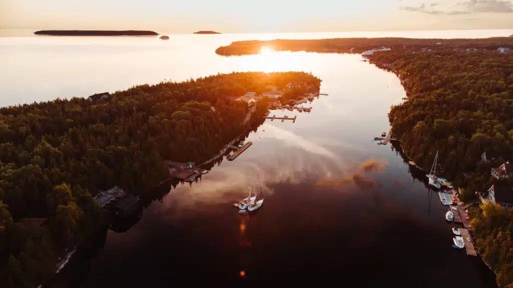 Drone view of Big Tub Harbor in Tobermory at dusk. Showing calm water and boats parked at docks.