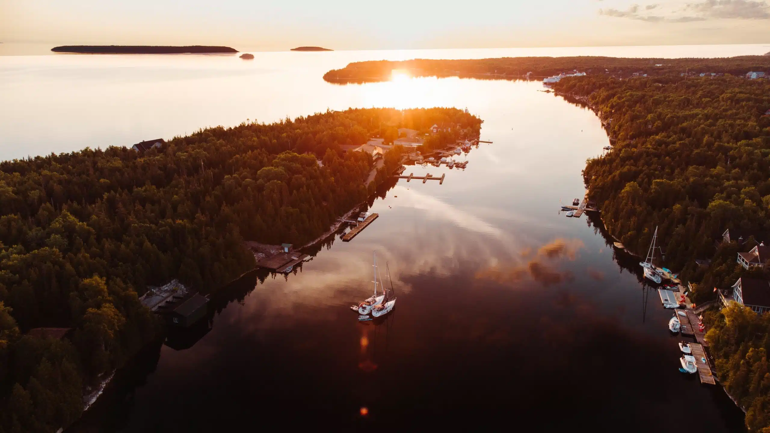 Drone view of Big Tub Harbor in Tobermory at dusk. Showing calm water and boats parked at docks.